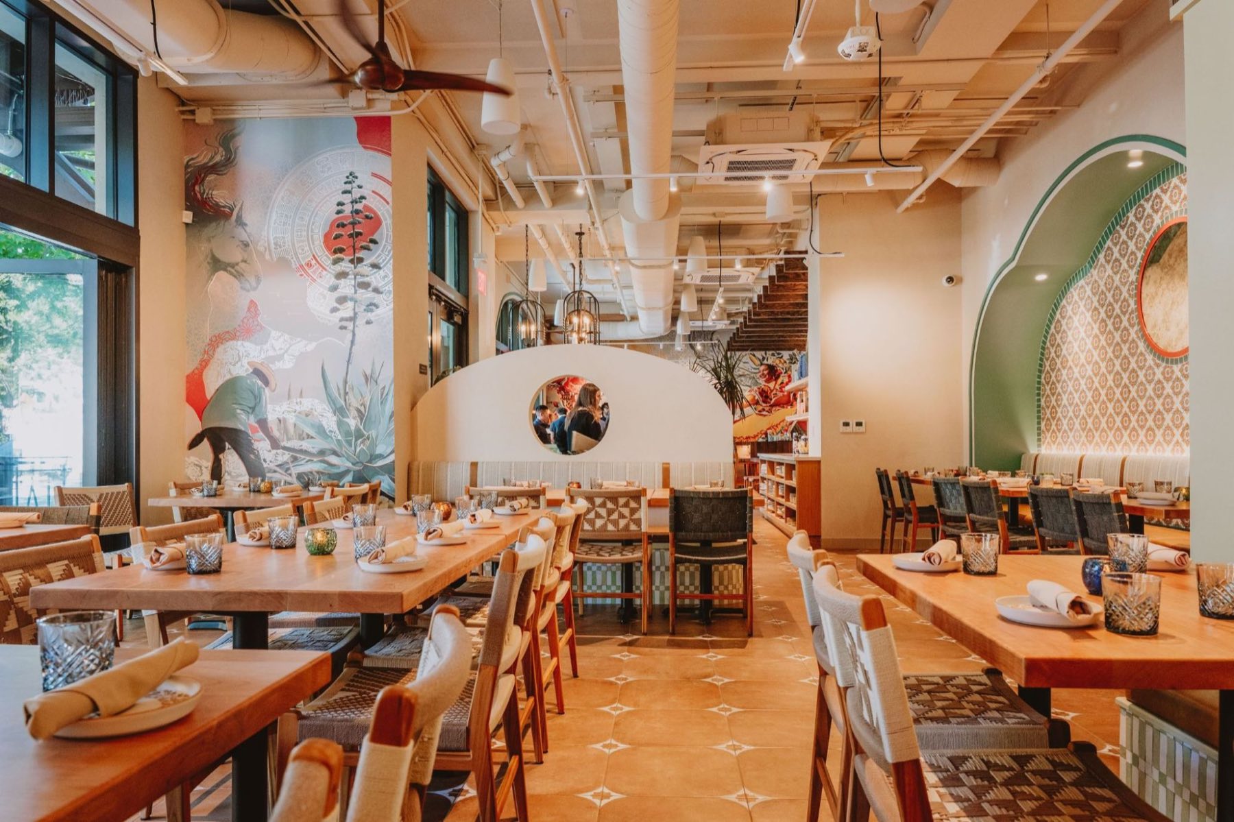 Alisios main dining room &mdash; agave and horse mural, terracotta tile floor, woven chairs and banquette seating