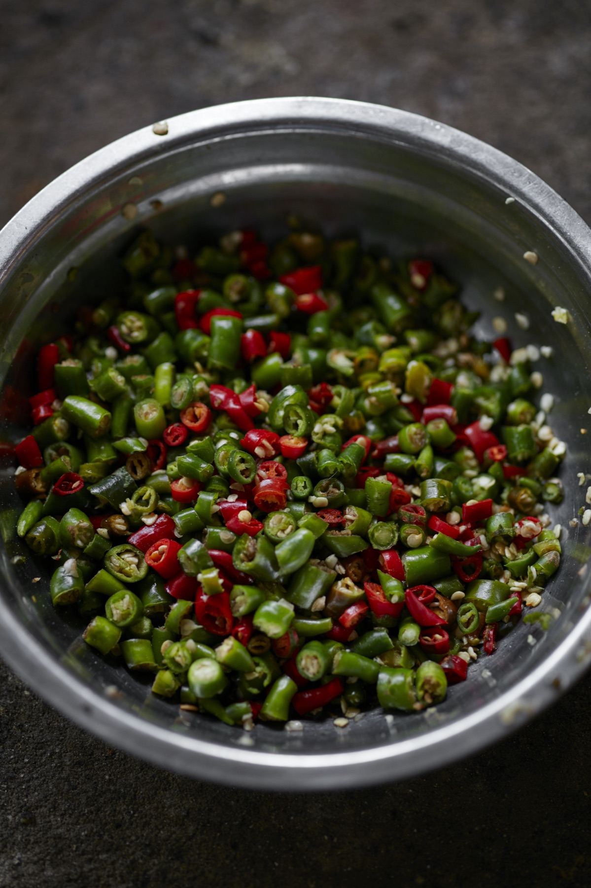 Fresh chopped chilies and long beans in a metal bowl