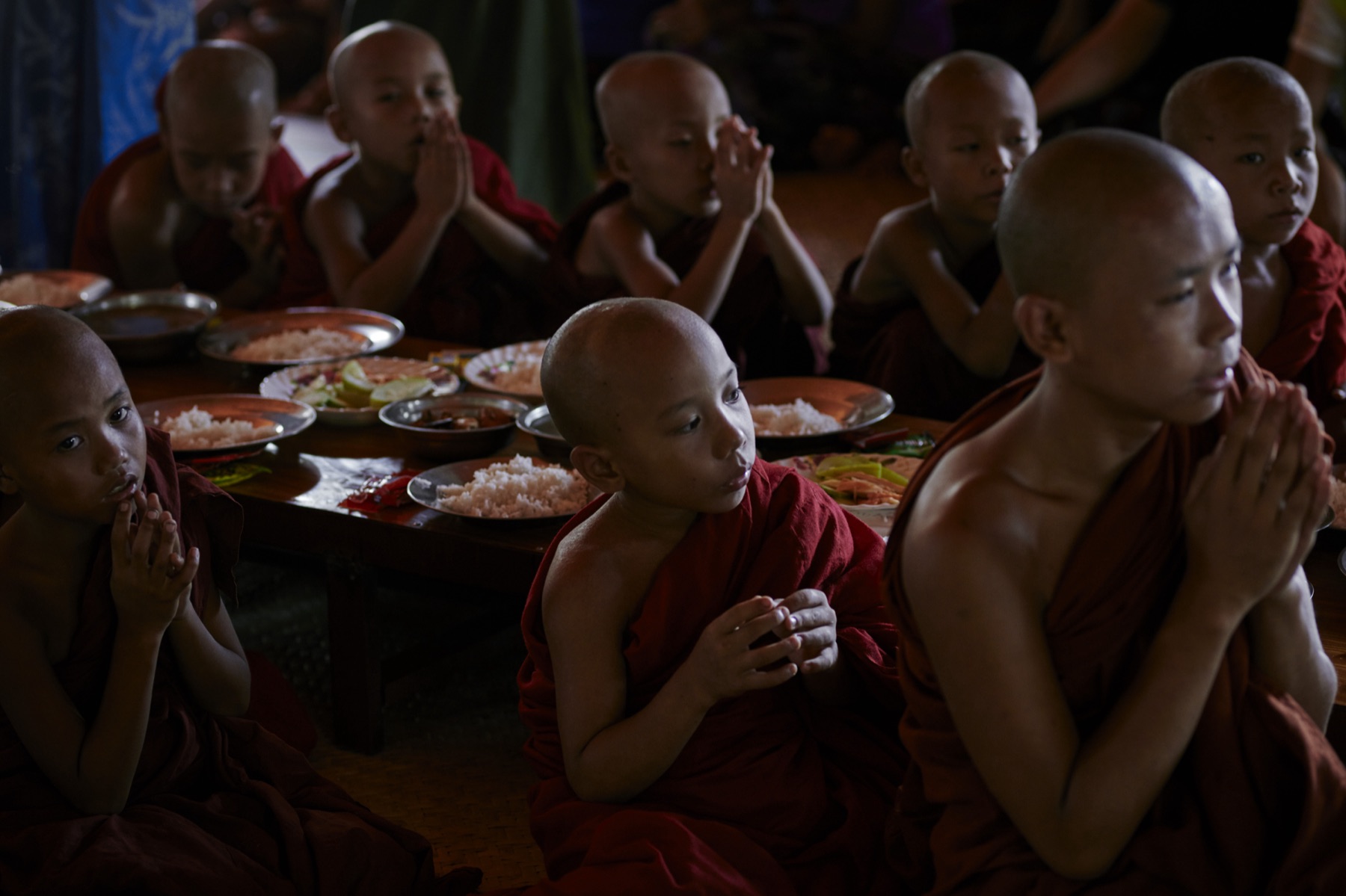 Young novice monks before a shared meal of rice
