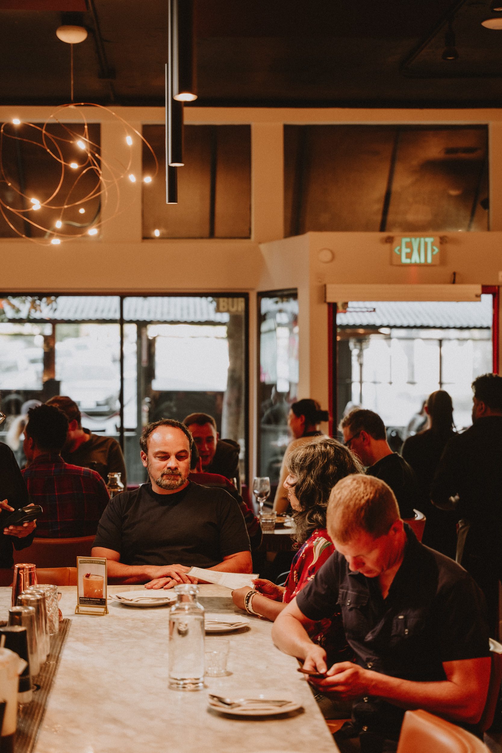 Burma Superstar Oakland — warm dining room with pendant lights, full house on Telegraph Avenue